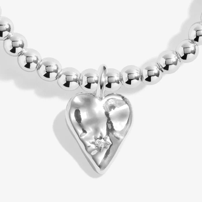A sleek silver bracelet with a heart charm, showcasing a blend of elegance and simplicity.