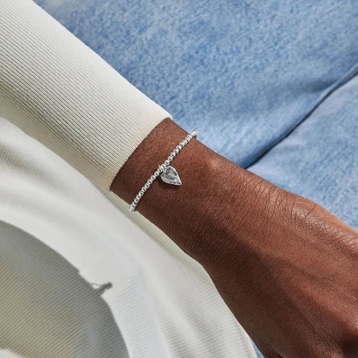 A refined silver bracelet with a heart charm, combining beauty and sentiment in its design.