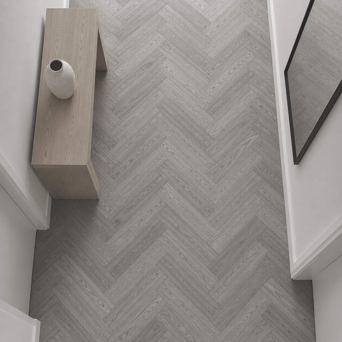 Elevated view of Alsace Oak Rigid LVT Herringbone flooring in a home hallway setting.