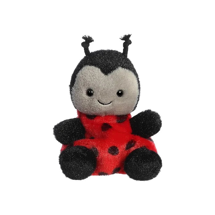A ladybug stuffed animal resting on a plain white background, showcasing its bright red and black features.