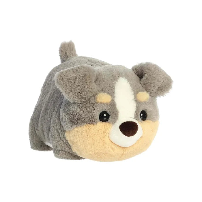 A plush dog toy with a white face and brown nose, positioned on a soft surface, showcasing its friendly expression.