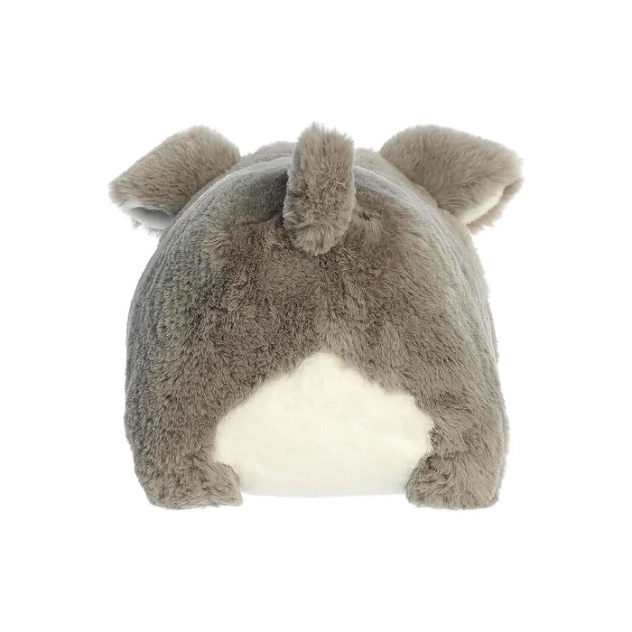 A cute stuffed animal dog with a white face and brown nose, displayed on a shelf among other toys.
