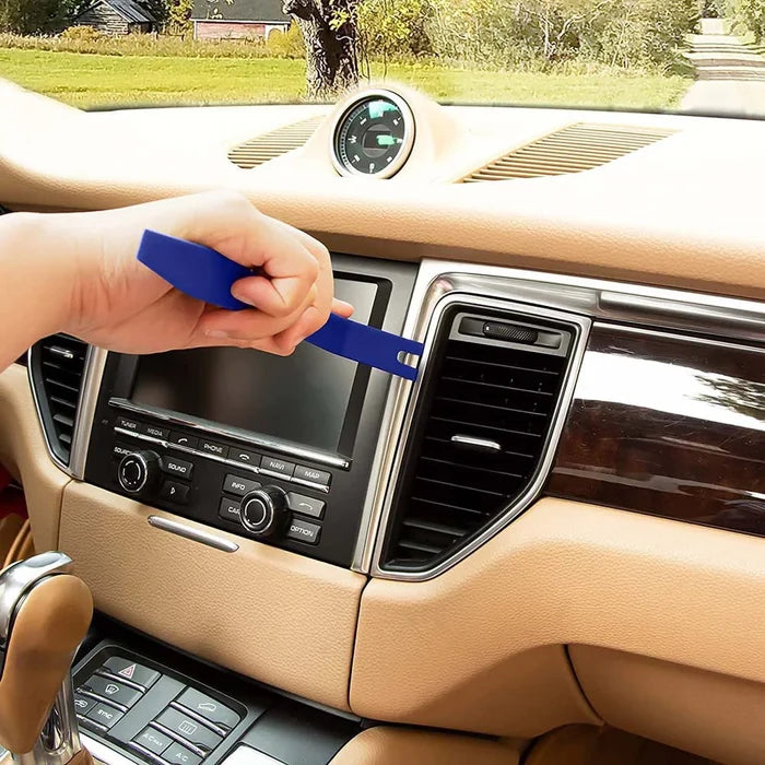 Person using a blue tool on a car dashboard