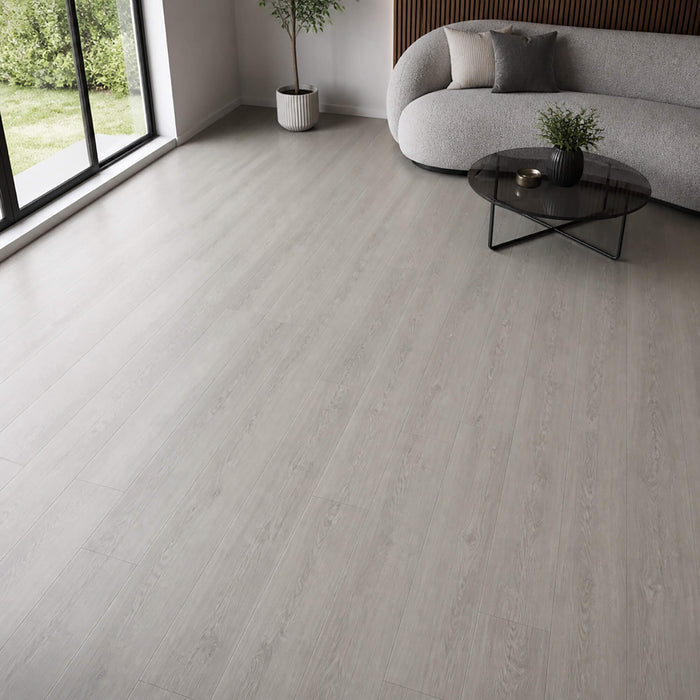 Modern living room with Causeway Grey Essentials laminate flooring, a grey sofa, and decorative elements.