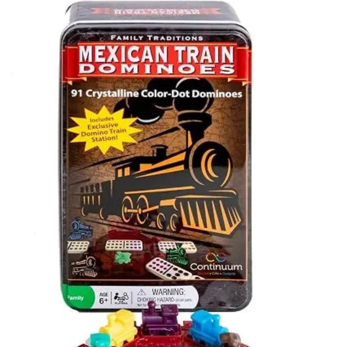 Mexican Train Dominoes set with a black metal tin box, white domino tiles with multicolored dots, a red train-themed game board, and colorful train car pieces on a white background.