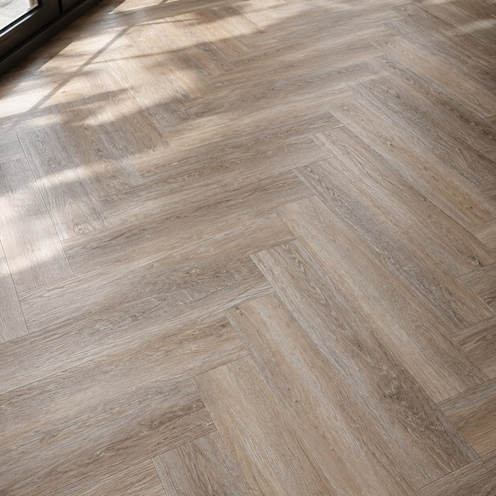 Close-up of Driftwood Oak Rigid LVT Herringbone flooring.