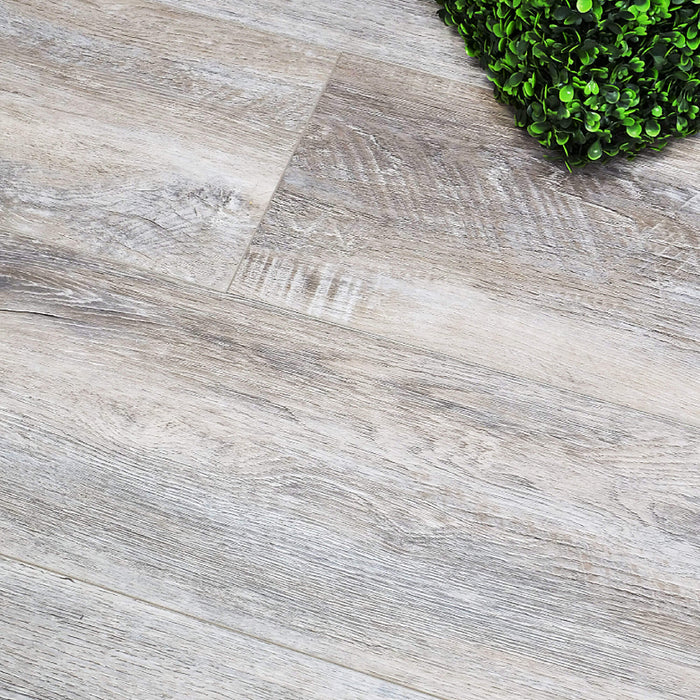 Close-up of Driftwood Oak Rigid LVT Super Plank Flooring with a paint in the corner.