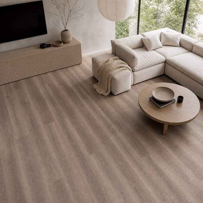 Modern living room with Dusky Oak Prestige Plus laminate flooring, beige sofa, and round coffee table.
