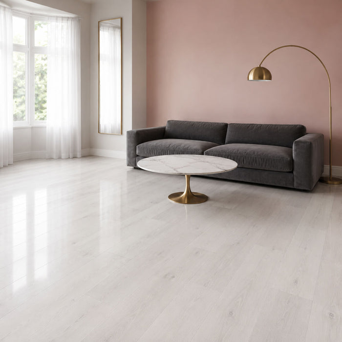 Fresco Pearl Super Gloss Laminate Flooring in a home living room setting with a sofa, table and lamp.
