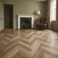 Victorian living room with a fireplace, leather armchair, and Fumed Oak Rigid LVT herringbone flooring.