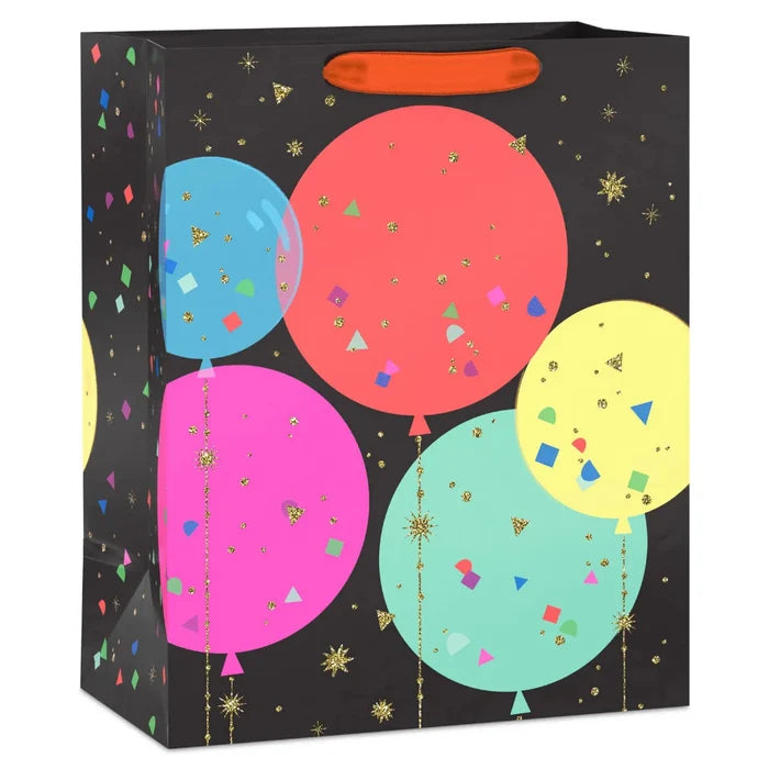 Large black gift bag with colorful balloon illustrations, confetti designs, and gold glitter accents