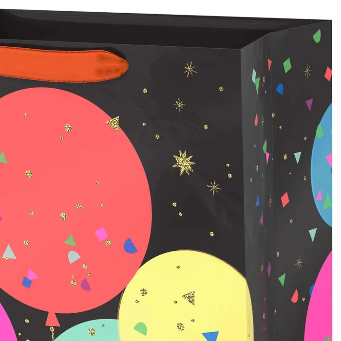 Close‑up of balloon‑design gift bag with gold glitter