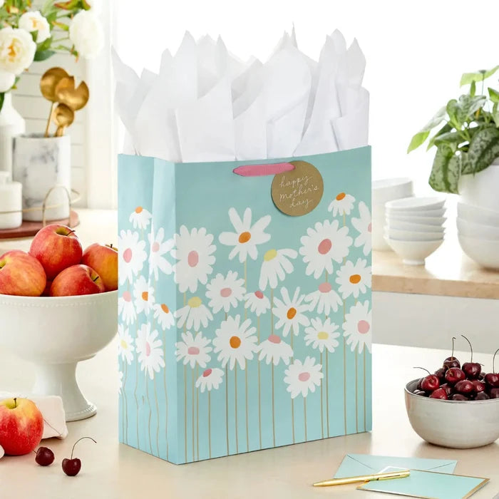 Extra‑large blue daisy Mother’s Day gift bag with gold accents displayed on a table beside a greeting card