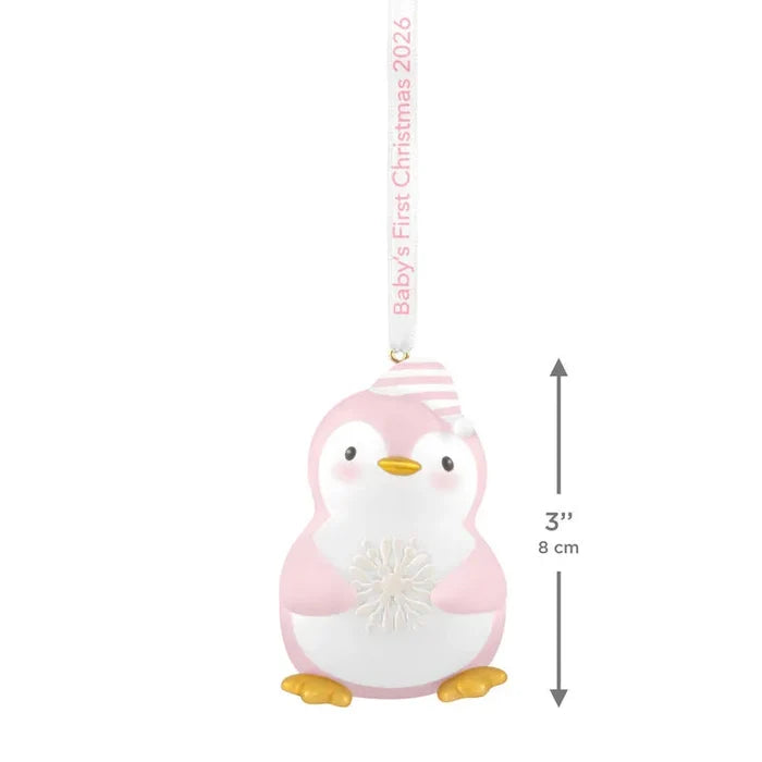 Pink and white plastic penguin ornament with striped hat holding snowflake for baby girl