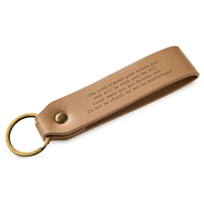 Brown leather keychain with engraved text on a white background