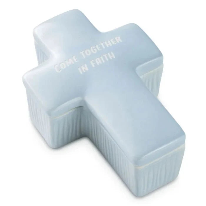 Light blue ceramic cross-shaped container with text on a white background