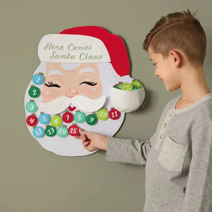 Child interacting with a Santa Claus-themed Advent calendar on a plain background