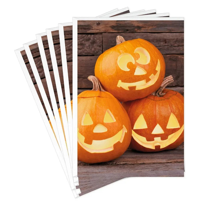 Hallmark Jack-o'-Lantern Trio Halloween card featuring three smiling pumpkins on a rustic wood-plank background.