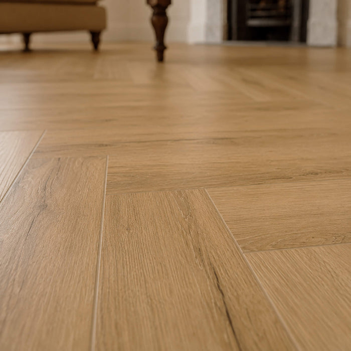 Close-up of a Heritage Oak Rigid LVT herringbone floor in a living room setting.