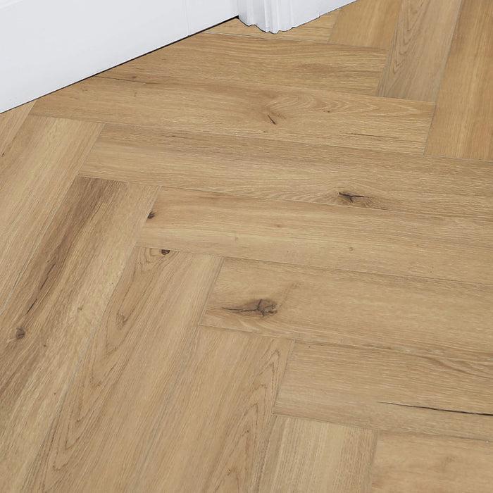 Heritage Oak Rigid LVT Herringbone Flooring with a white door and architrave in the background