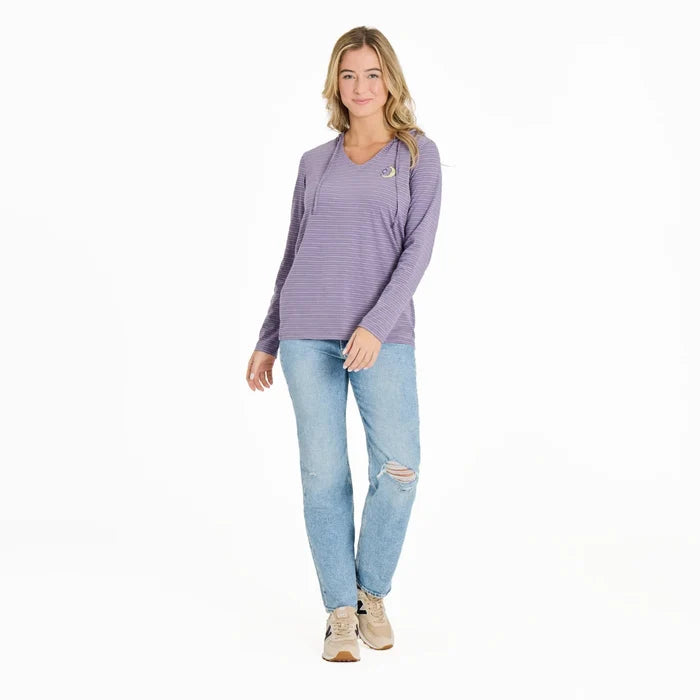 Woman wearing a purple long-sleeve shirt and light blue jeans on a white background