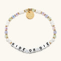 Bracelet with 'Ride or Die' beads and gold charm on a white background