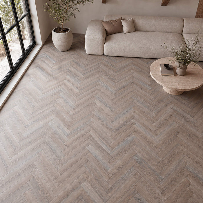 Manor Grey Oak Herringbone laminate flooring in a modern living room setting.
