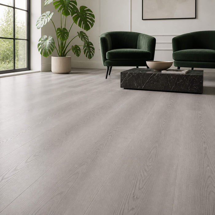 Living room with green chairs, a plant, and a marble coffee table on Misty Grey Prestige Plus laminate flooring.