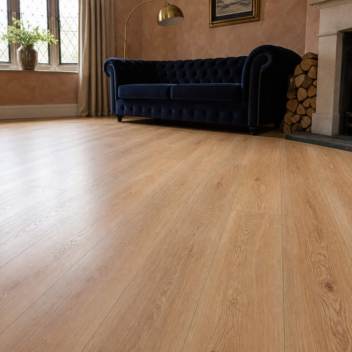 Living room with Natural Oak Rigid LVT wooden flooring, blue sofa, and fireplace.