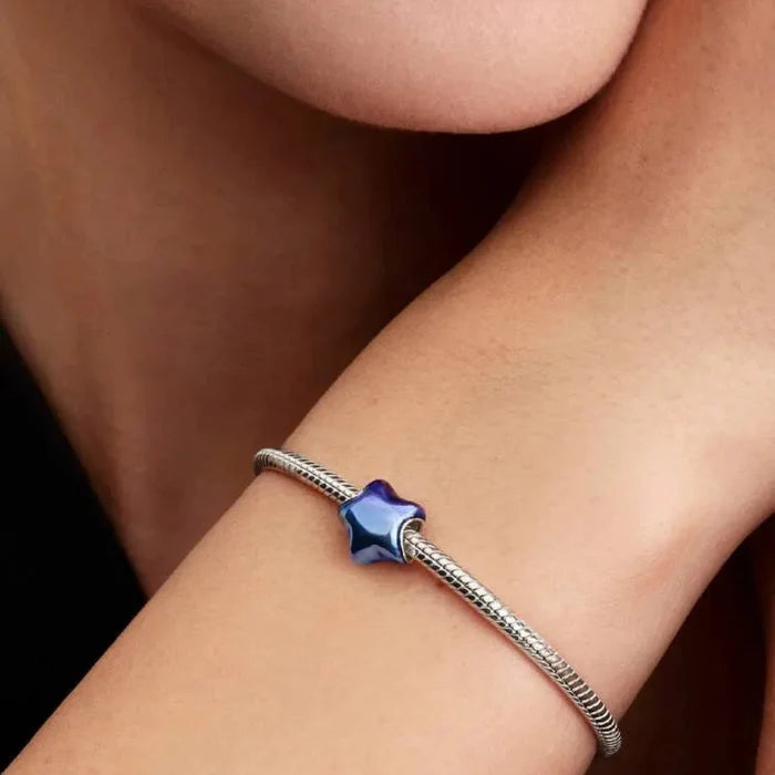 Blue enamel puffy star charm worn on a chain