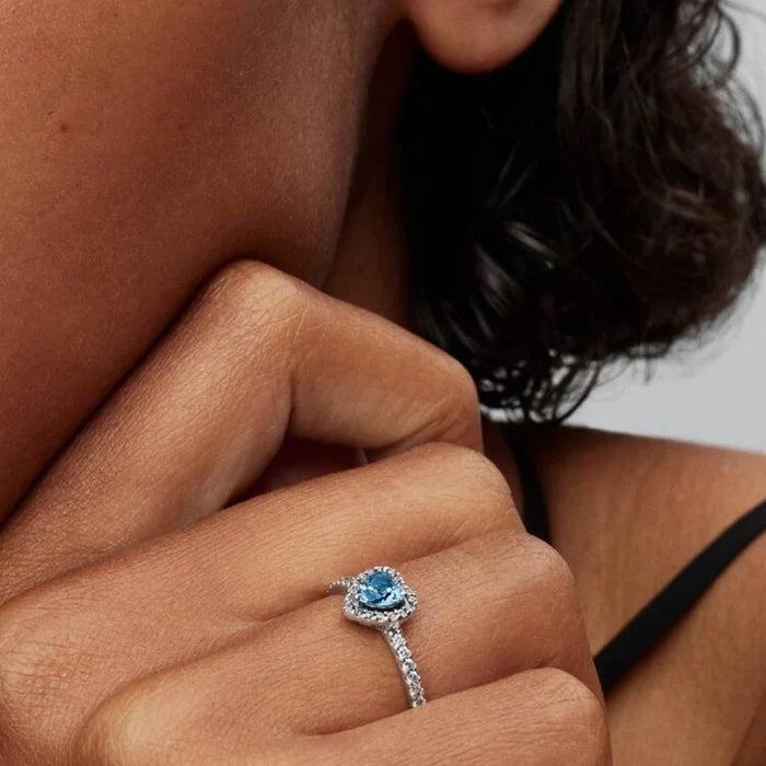 A blue topaz ring embellished with a circle of white diamonds.