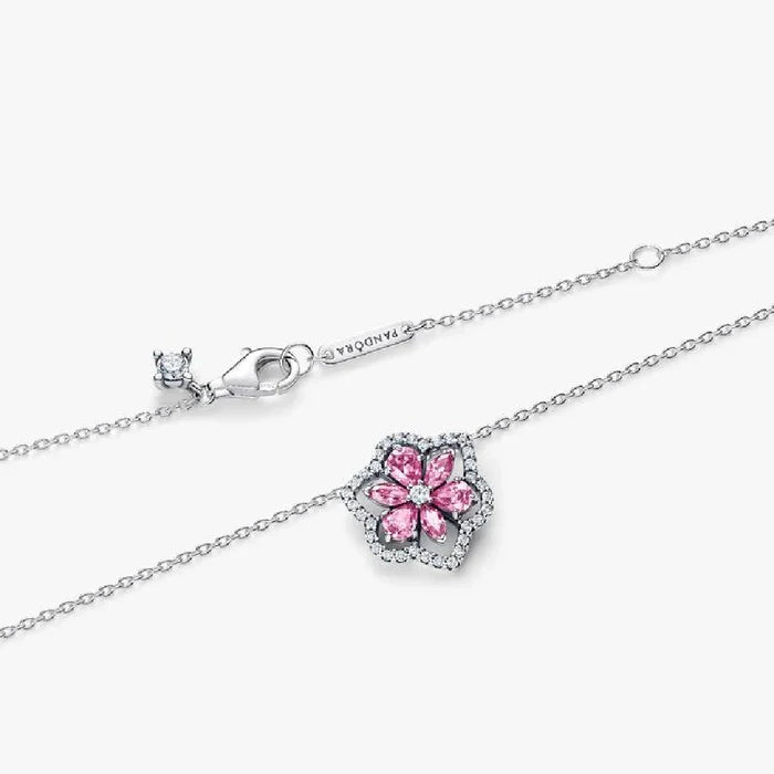 A pink flower pendant with diamond accents, gracefully suspended on a fine chain.
