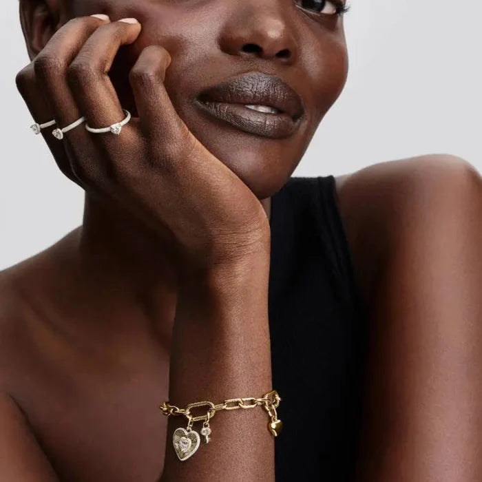 14k gold‑plated key dangle charm with cubic zirconia worn on a wrist alongside coordinating gold jewelry