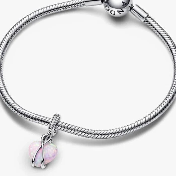 This Pandora Mum Opalescent Heart Dangle Charm offers a beautiful way to celebrate the special bond between a mother and child.