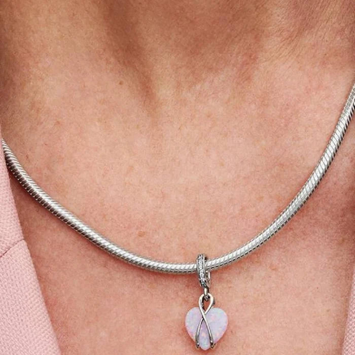 This Pandora Mum Opalescent Heart Dangle Charm offers a beautiful way to celebrate the special bond between a mother and child.