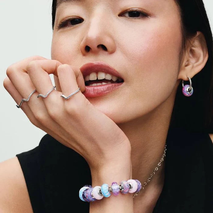 This Pandora Opalescent Purple Charm adds an enchanting pop of color to your jewelry collection.