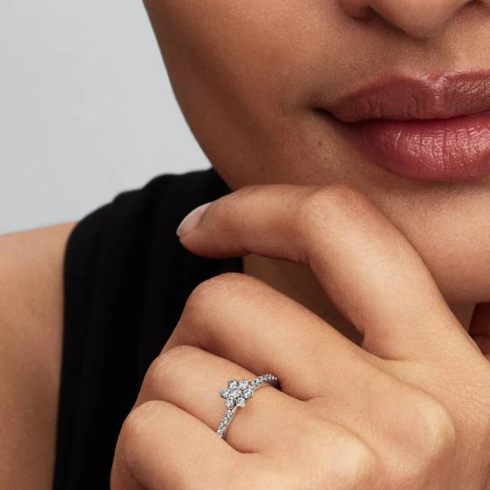 A diamond flower ring crafted with a white gold band, featuring a unique floral design embellished with sparkling diamonds.