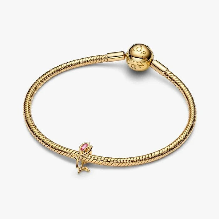 Elegant gold plated rose charm embellished with pink stones, perfect for adding a touch of sophistication.