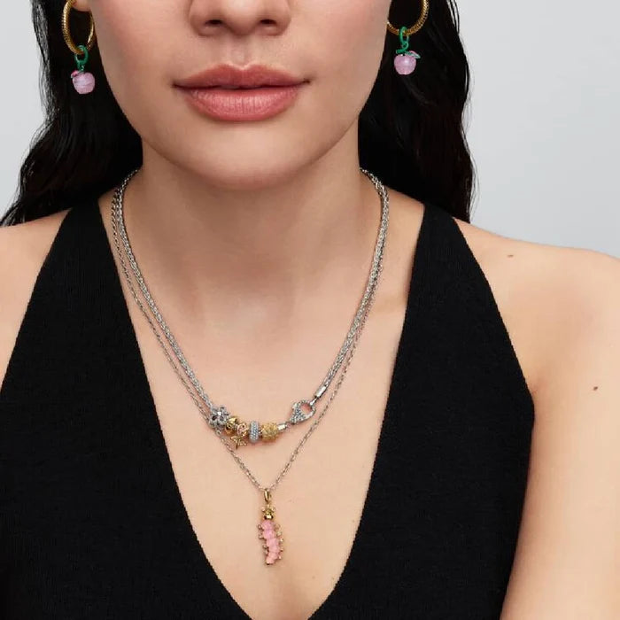 Gold plated rose charm with pink stones, representing a blend of luxury and floral beauty in jewelry design.