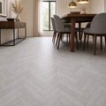 Dining room with wooden table and chairs on a Pyrenees Oak rigid LVT Herringbone flooring.