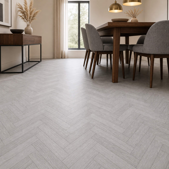 Dining room with wooden table and chairs on a Pyrenees Oak rigid LVT Herringbone flooring.