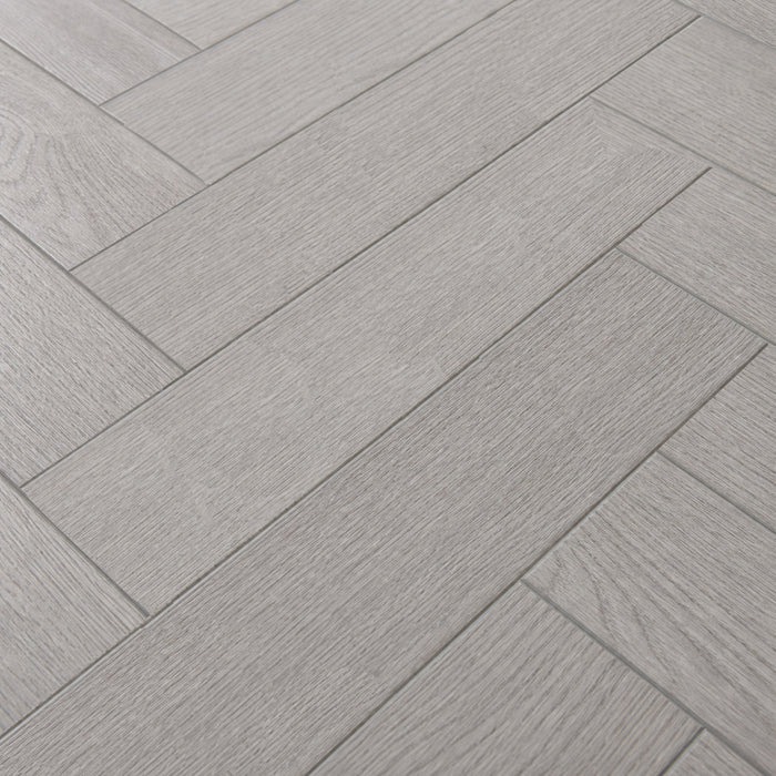 Close-up of the pattern and texture of Pyrenees Oak rigid LVT Herringbone flooring.
