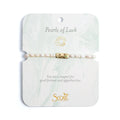 Elegant bracelet featuring pearls, symbolizing luck and charm, displayed on a soft fabric background.