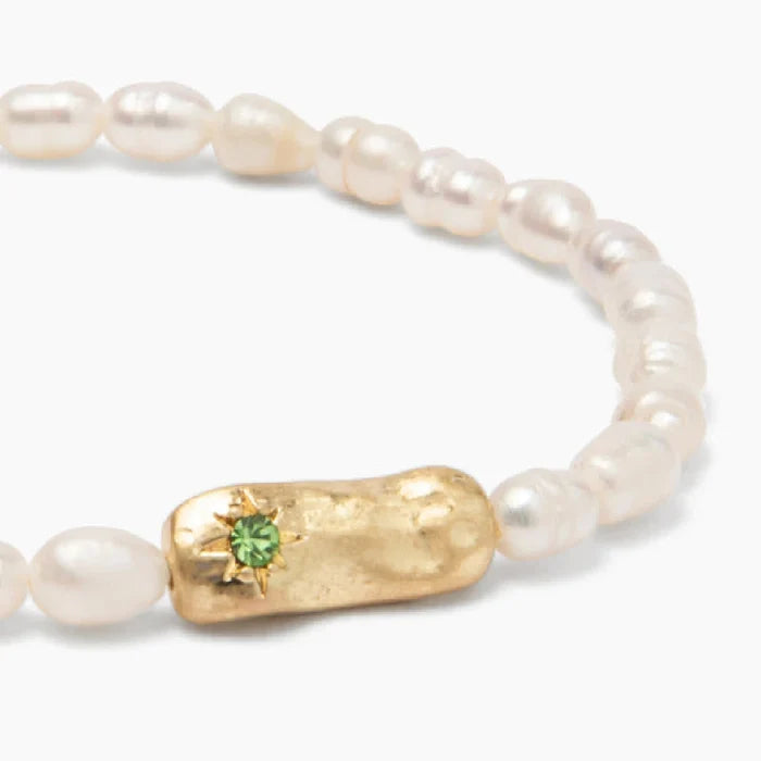 Charming bracelet of pearls, symbolizing luck, displayed on a soft, neutral background for emphasis.