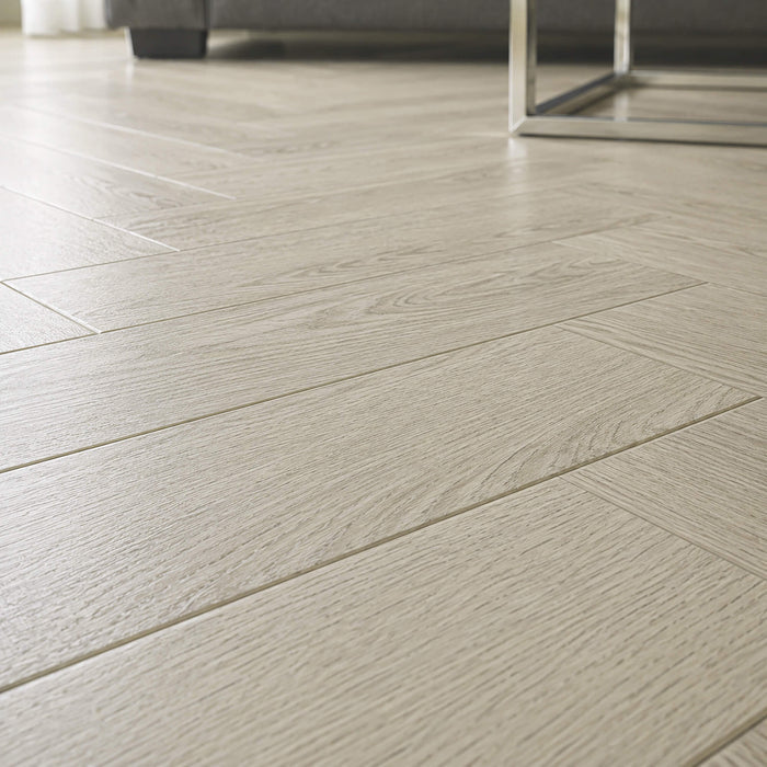 Close-up of Siberian Oak Rigid LVT herringbone flooring in a living room setting.