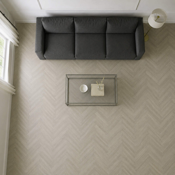 Elevated view of a Siberian Oak Rigid LVT herringbone flooring in a living room setting.