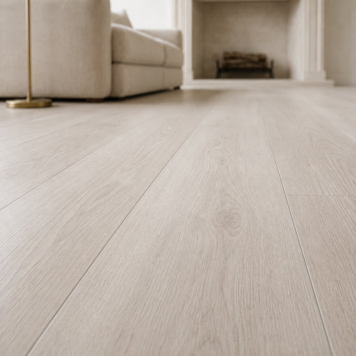 Close-up of Siberian Oak Rigid LVT flooring in a living room with a couch and lamp.