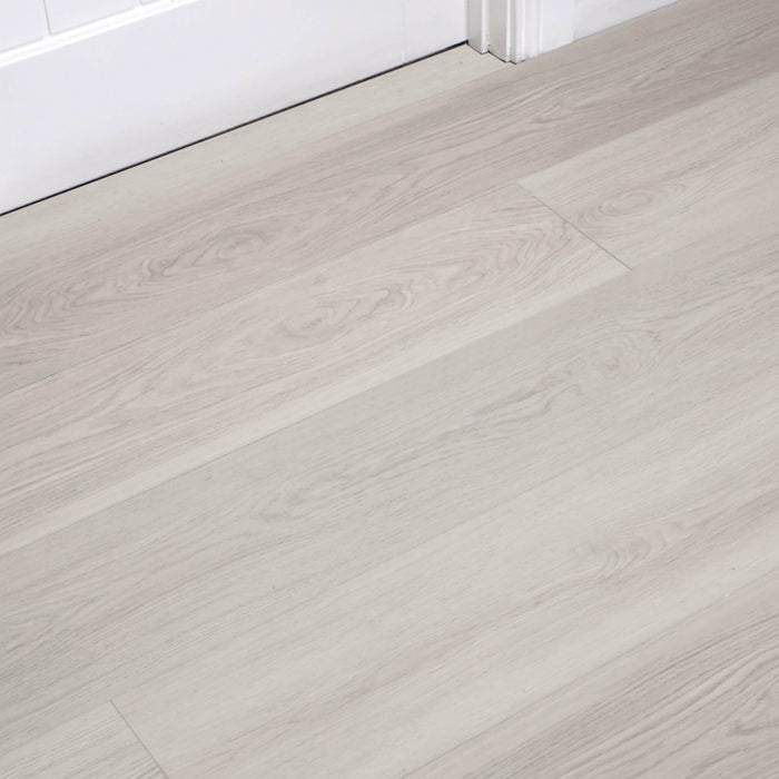Siberian Oak Rigid LVT flooring with a white architrave and door in the background.