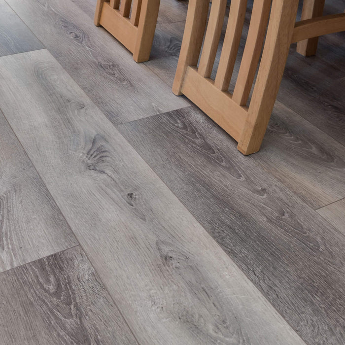 Silver Grey Oak Prestige Laminate flooring with wooden chair legs in the background