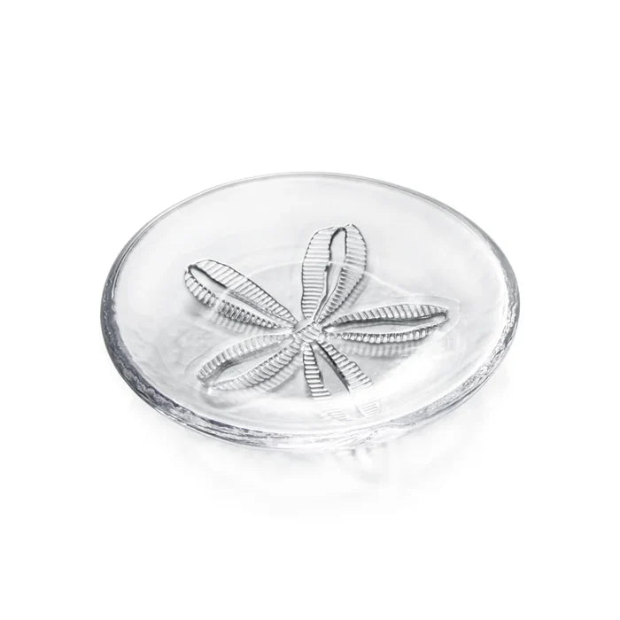 A white plate displaying a sand dollar design, emphasizing coastal themes.